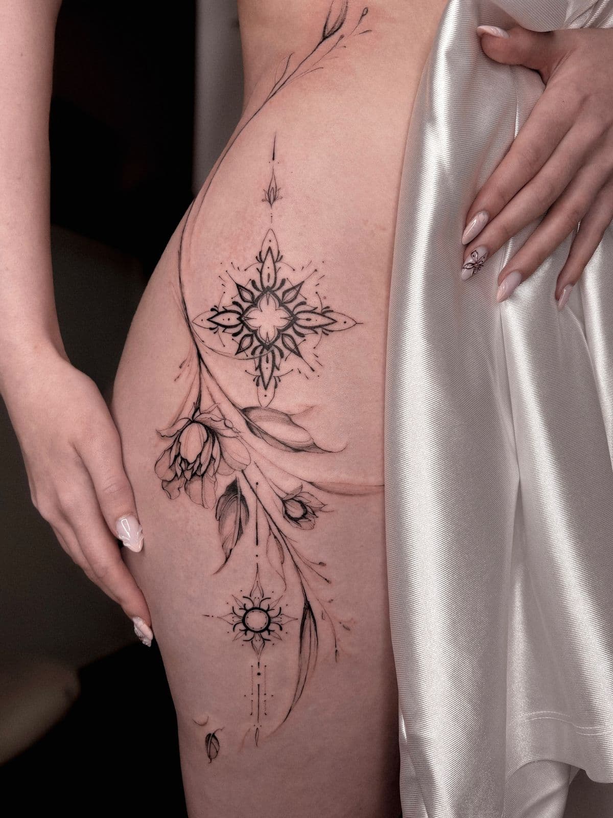 Ornamentale Fine-Line-Arbeit an der Hüfte – Mandala, Blüten und Sonnenmotive