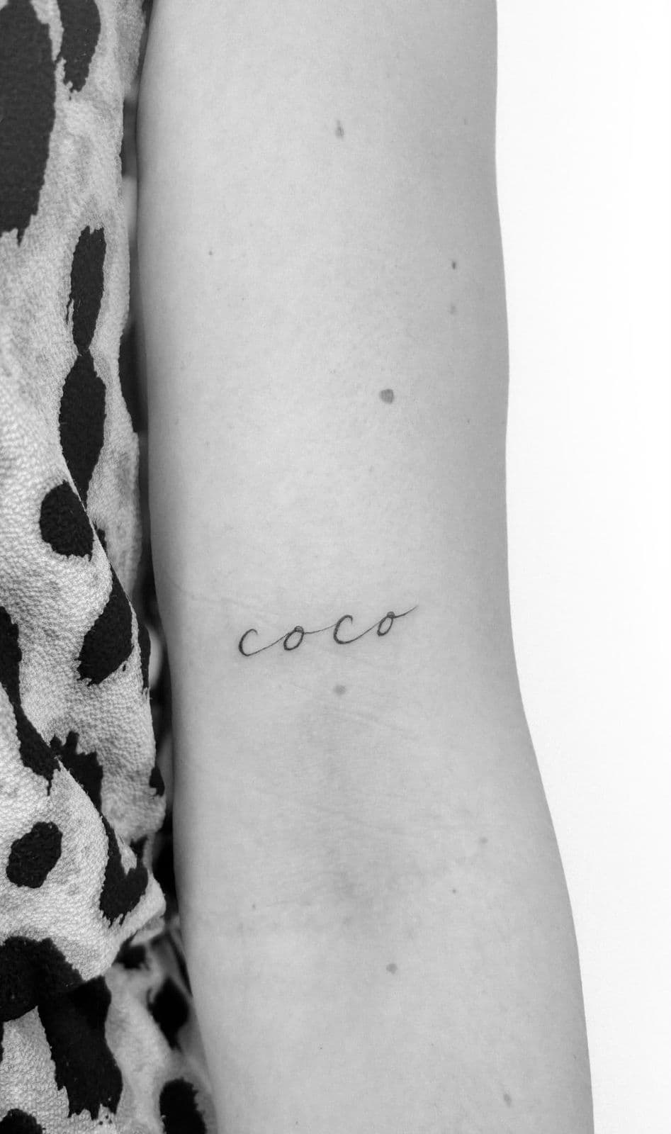 Schriftzug ‚coco‘ am Unterarm