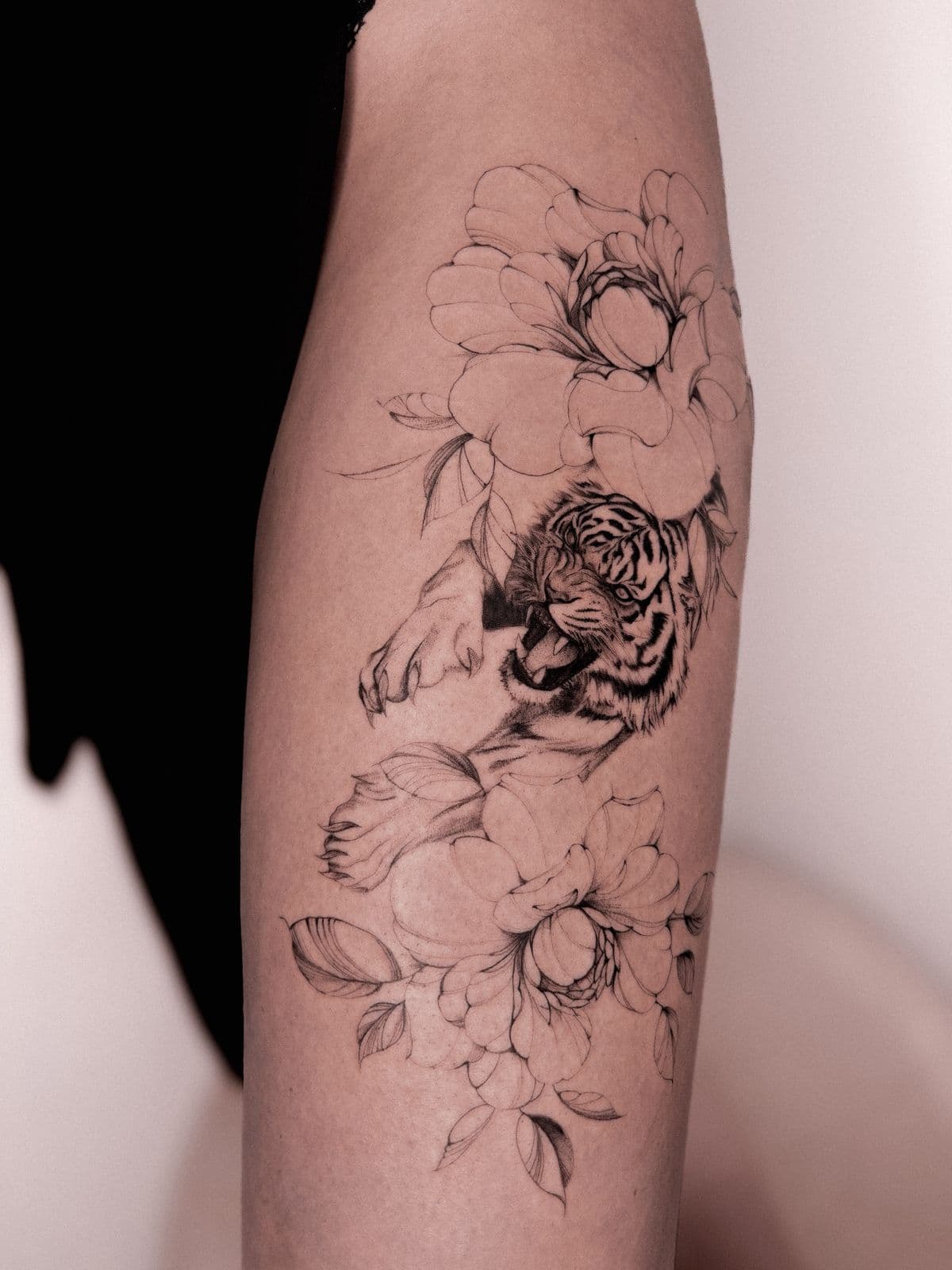 Tiger umrahmt von Blüten am Arm